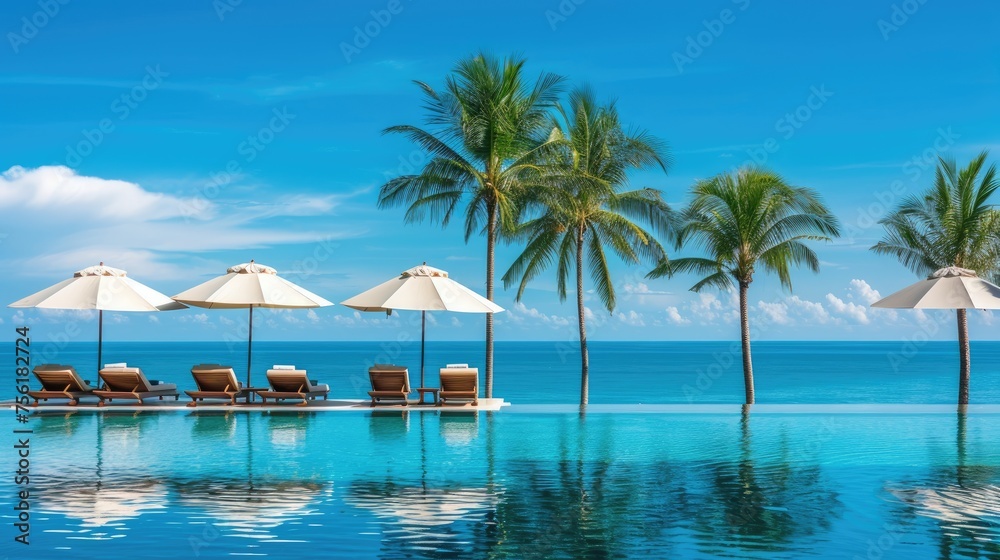 Luxurious swimming pool with loungers, umbrellas, palm trees, and sea under a blue sky. Ai Generated