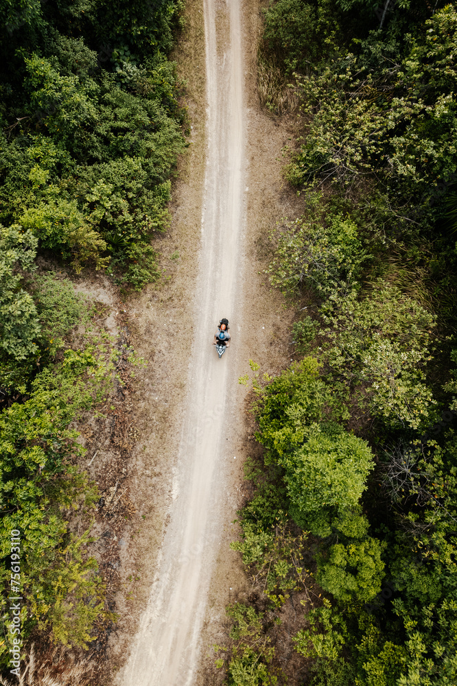 Aerial view of a motorbike travelling along a country track in the Philippines