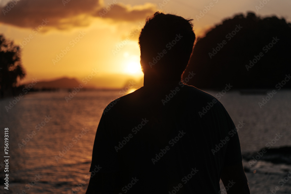 Silhouette of a man watching the sunset over the beach in the Philippines