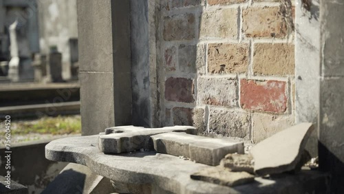 A stone cross lays beside an old grave photo