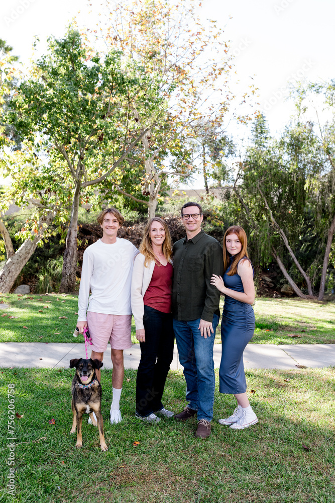 Family of Four Smiling for Camera with Dog in Park in San Diego