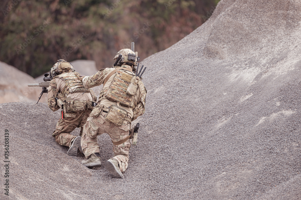 Obraz premium Soldiers in camouflage military uniforms carrying weapons, Reconnaissance missions in rugged mountains, Assault infantry battle training.