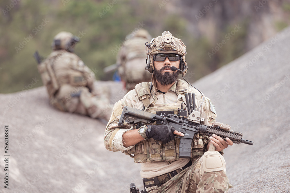 Fototapeta premium Soldiers in camouflage military uniforms carrying weapons, Reconnaissance missions in rugged mountains, Assault infantry battle training.