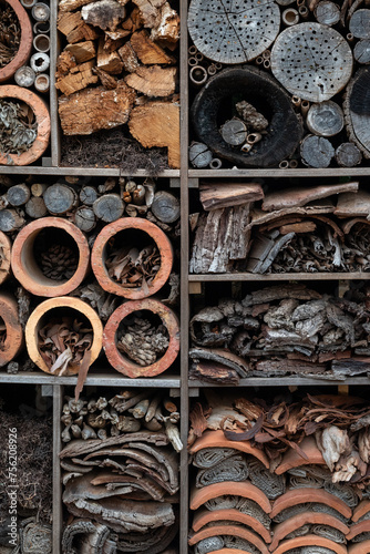 Closeup of a mixture of wooden, pottery, and cardboard items in an insect hotel