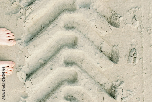 Feet and Tire Tracks in Sand
