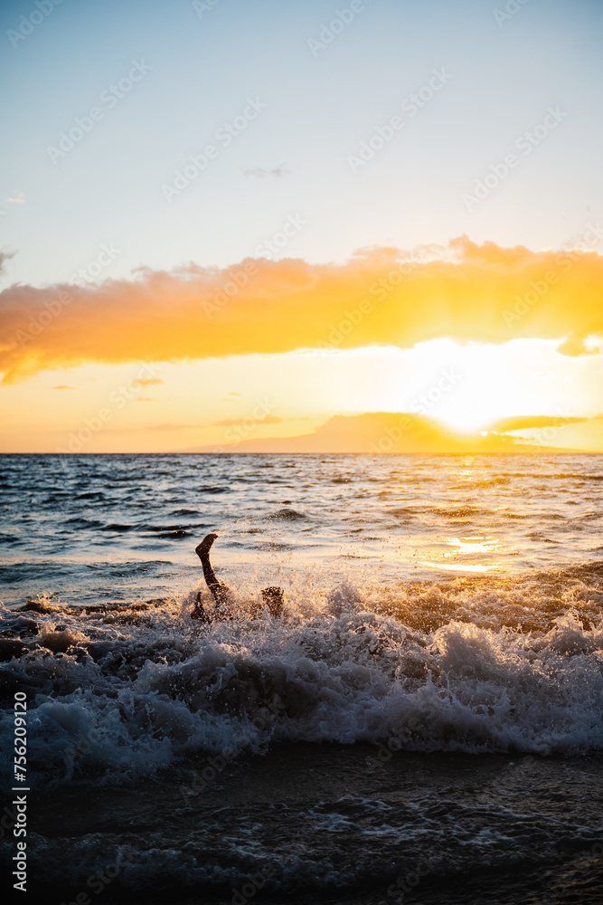 Silhouette splashing in the Maui sunset