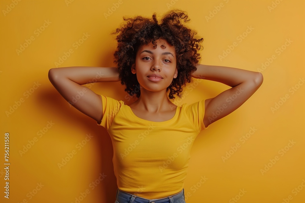 A woman with curly hair is wearing a yellow shirt and jeans A woman with curly hair is wearing a yellow shirt and jeans