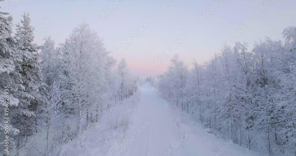Aerial view of a road in the middle of frosty forest, polar night in Lapland Aerial view of a road in the middle of frosty forest, polar night in Lapland