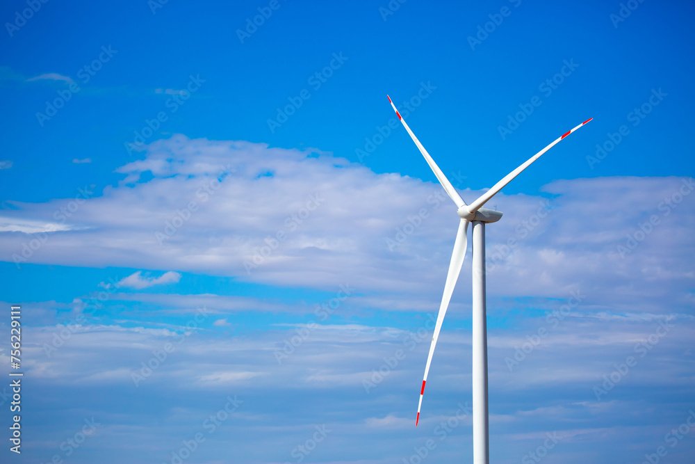 Fleet of power generators in motion. The blades of the wind farm rotate against the sky. The concept of extracting electricity from renewable sources. Wind turbine to generate electricity. Fleet of power generators in motion. The blades of the wind farm rotate against the sky. The concept of extracting electricity from renewable sources. Wind turbine to generate electricity.