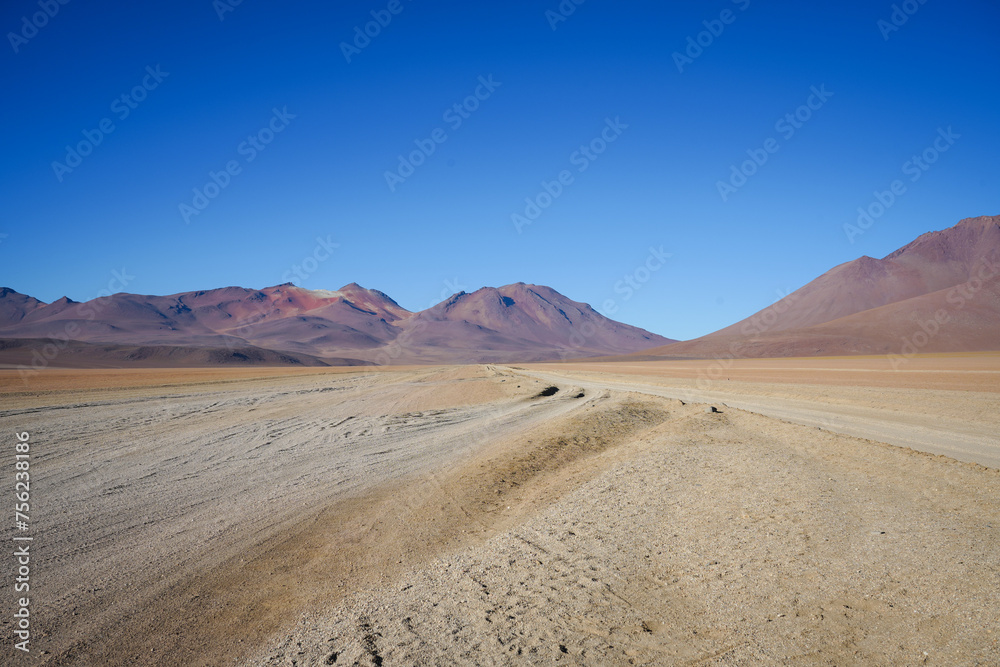 Dirt Tracks in Red Sand Desert, Blue Sky Background - Salar de Uyuni, Bolivia 
