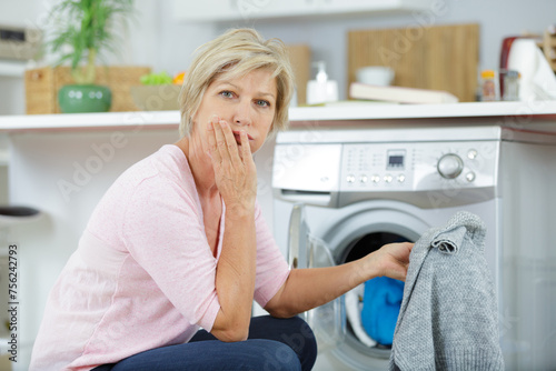 tired woman with laundry basket near washing machine