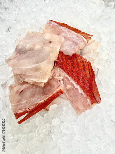 fresh raw cold seafood Seven star whole fish ikan head, fillet, meat, cut, tail on white ice background halal food cuisine hyper market menu for restaurant ingredient design photo