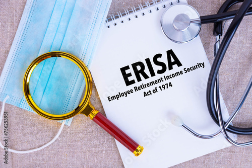 Employee Retirement Income Security Act ERISA , the text is written on a notepad, next to a pen, a disposable medical mask, a stethoscope on a linen background. photo