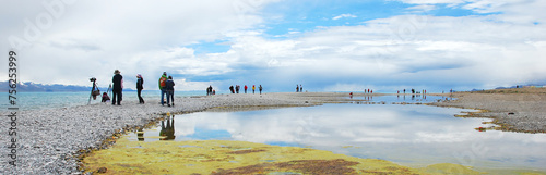 The clear water of Namtso Lake and tourists