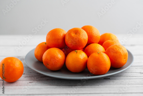 A plate of oranges is on a table
