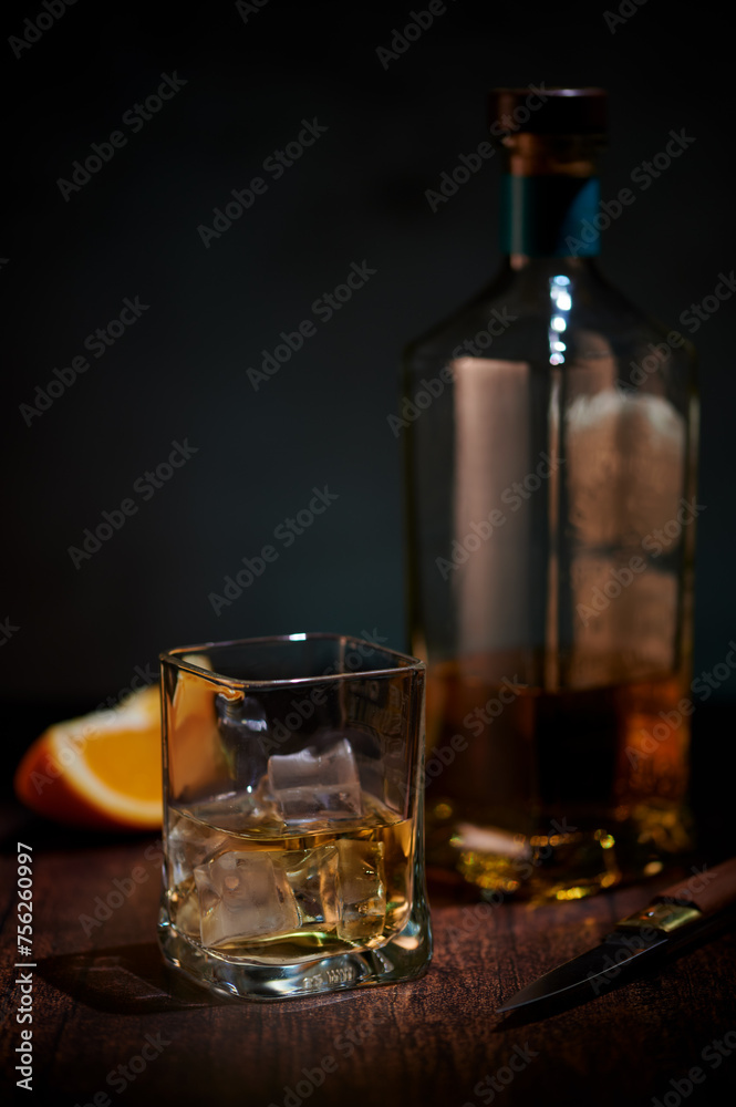 Glass whisky on ice with piece of orange Glass whisky on ice with piece of orange