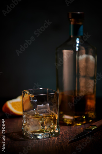 Glass whisky on ice with piece of orange