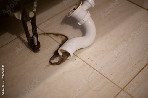 Flood in the bathroom due to a clogged pipe. A pipe in the bathroom due to clogged long hair