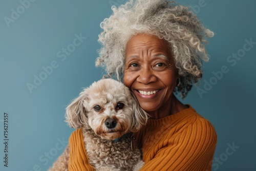portrait of an elderly black afro american woman holding a little dog in her hands