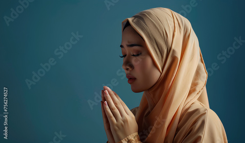 Indonesian hijab woman raising her hands while praying in sadness (ID: 756274527)
