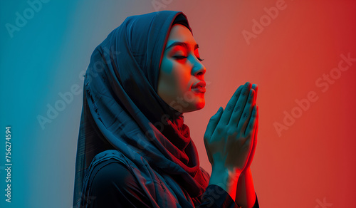 Indonesian woman wearing hijab praying on a red background (ID: 756274594)