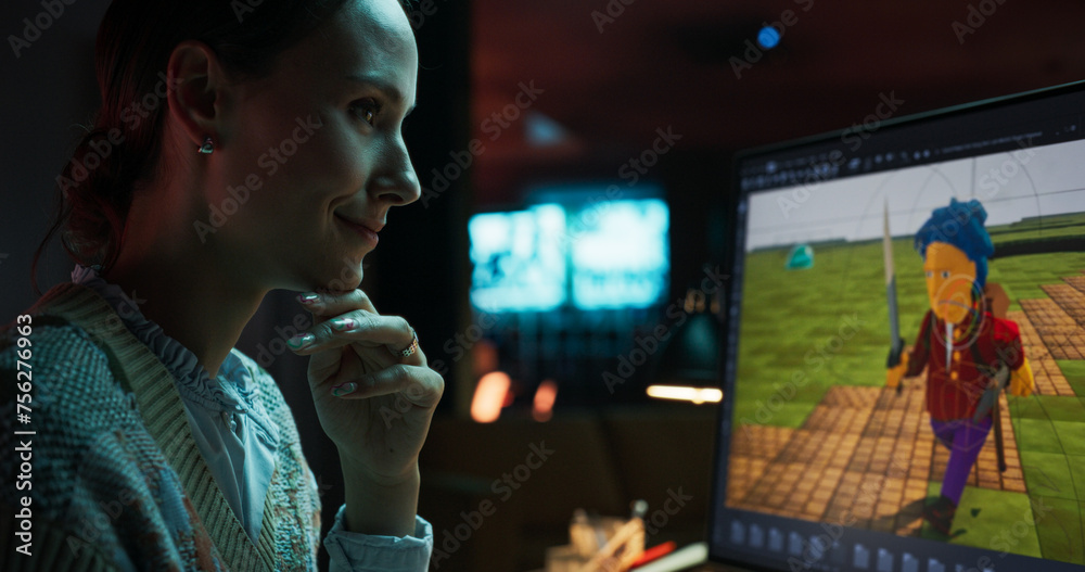 Portrait of Female Video Game Designer Working on a New 3D Level on Her Desktop Computer. Focused Woman Creating Metaverse and Design Video Game Character in Creative Office at Night