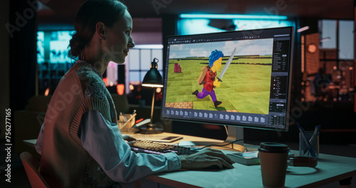 Portrait of Female Video Game Designer Working on a New 3D Level on Her Desktop Computer. Focused Woman Creating Metaverse and Design Video Game Character in Creative Office at Night