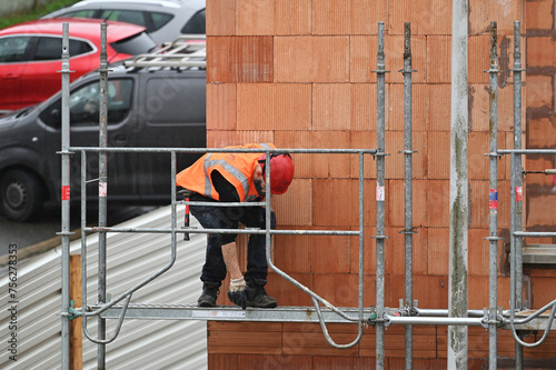 monteur d'échaffaudage sur un chantier de cosntruction photo