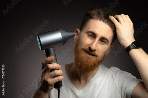 man drying hair with hairdryer