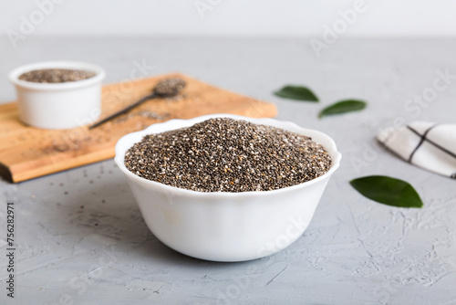 Chia seeds in bowl and spoon on colored background. Healthy Salvia hispanica in small bowl. Healthy superfood