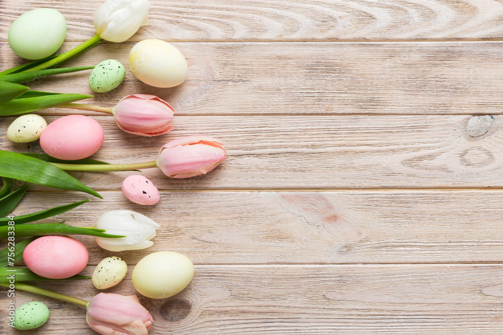 Happy Easter composition. Easter eggs on colored table with yellow Tulips. Natural dyed colorful eggs background top view with copy space Happy Easter composition. Easter eggs on colored table with yellow Tulips. Natural dyed colorful eggs background top view with copy space