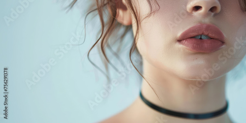 Elegant Beauty Young Woman with Choker.  Close-up of a girl with black choker on her neck  grey background with copy space.
