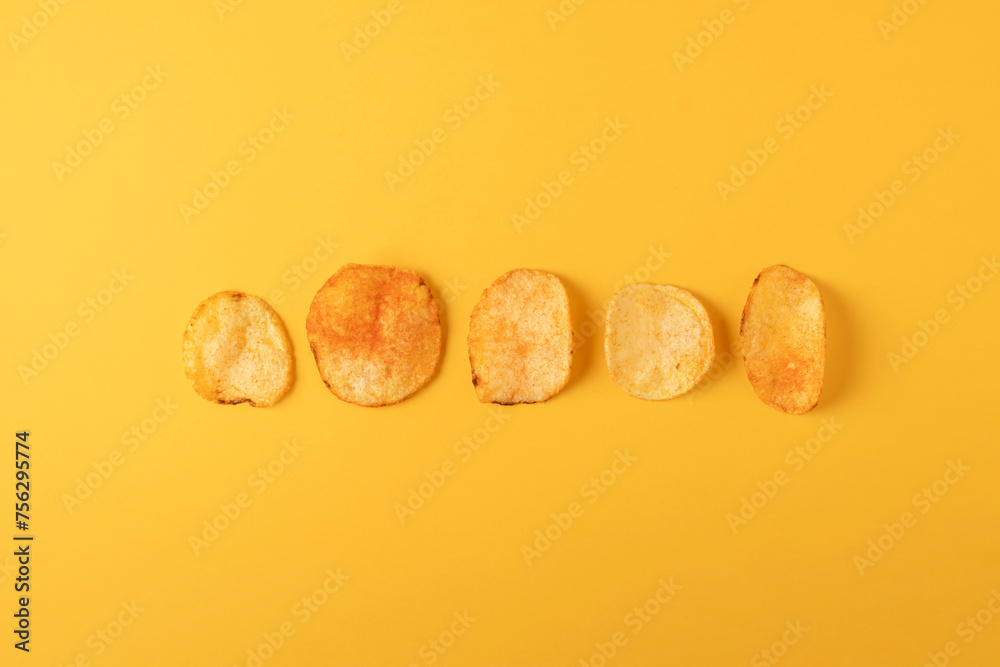 Potato chips on yellow background. Flat lay, top view.