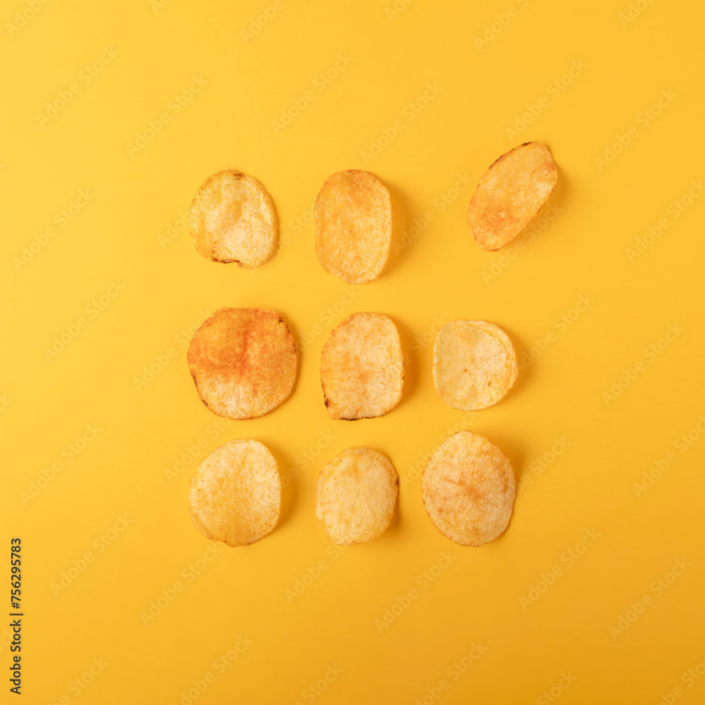 Potato chips on yellow background. Flat lay, top view. Potato chips on yellow background. Flat lay, top view.
