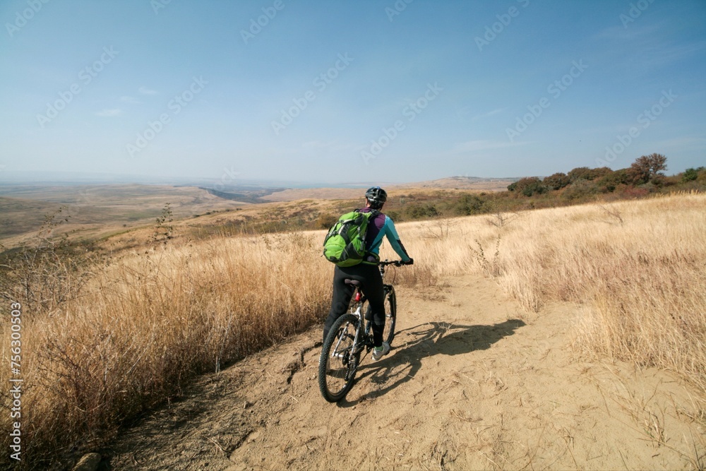 A cyclist admires the view of the steppe, Russia.