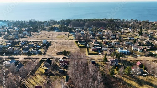 Aerial View Over the Town Saulkrasti and Zvejniekciems, Latvia. Pine Forest With Wooden Pathway and Summer Hauses Near Baltic Sea Coast Against Beautiful Blue Sky. Sunny Spring Day photo