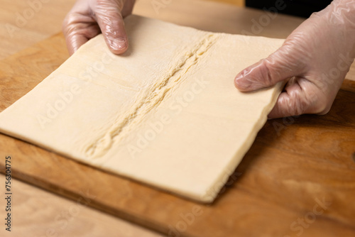 Roll out a sheet of puff pastry. Making puff pastry pies.