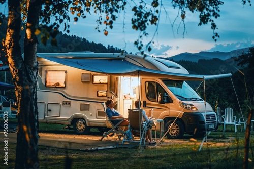 Warm lights and a serene setting depict a relaxing moment at the campsite with a motorhome