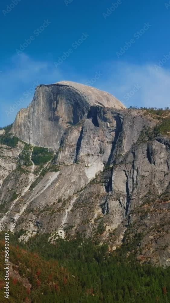 Slow motion approach to the cliffs in Yosemite National Park, California, USA. Pine tree wood growing at the foot of mountain. Vertical video. Slow motion approach to the cliffs in Yosemite National Park, California, USA. Pine tree wood growing at the foot of mountain. Vertical video.