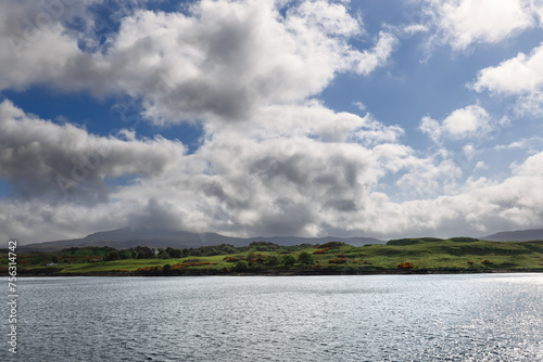 A serene seascape captures the tranquility of the waters near Skye  with gentle hills and a dynamic skyscape completing the scene