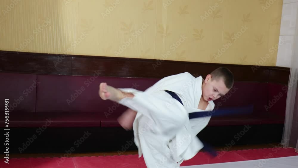 An athlete with a blue belt trains punches and kicks in motion