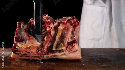 il macellaio taglia la bistecca con il coltello affilato.
in macelleria: Primo piano della carne rossa da cuocere alla griglia. photo