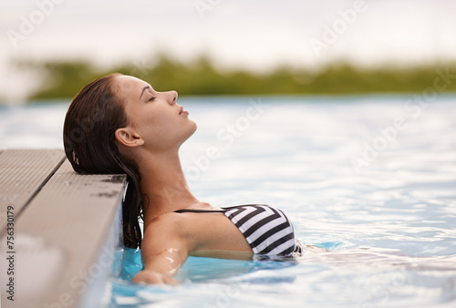 Summer, peace and woman relax in swimming pool on luxury holiday or vacation at hotel or villa in Cancun. Person, outdoor or enjoy calm water at resort in Mexico or girl in bikini or swimsuit fashion