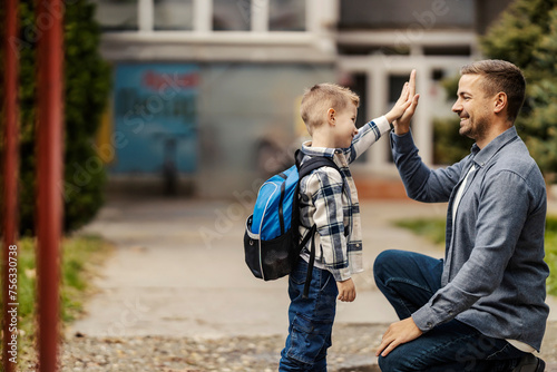 Картината върху платно A father is giving high five to his kindergartener on school entrance