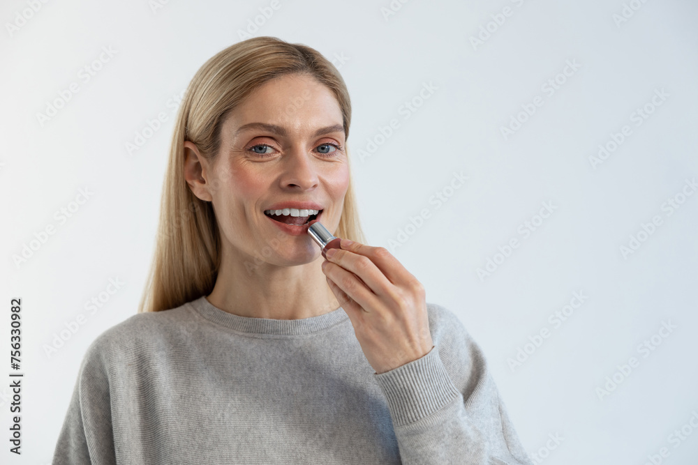 Pretty young blonde woman doing make up and smiling Pretty young blonde woman doing make up and smiling