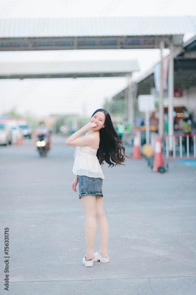 Beautiful Asian woman poses in fashion style, white shirt, jeans skirt.
