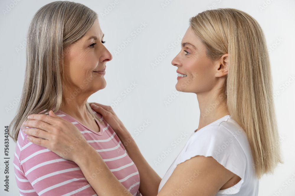 Loving mom and daughter standing together and feeling peaceful