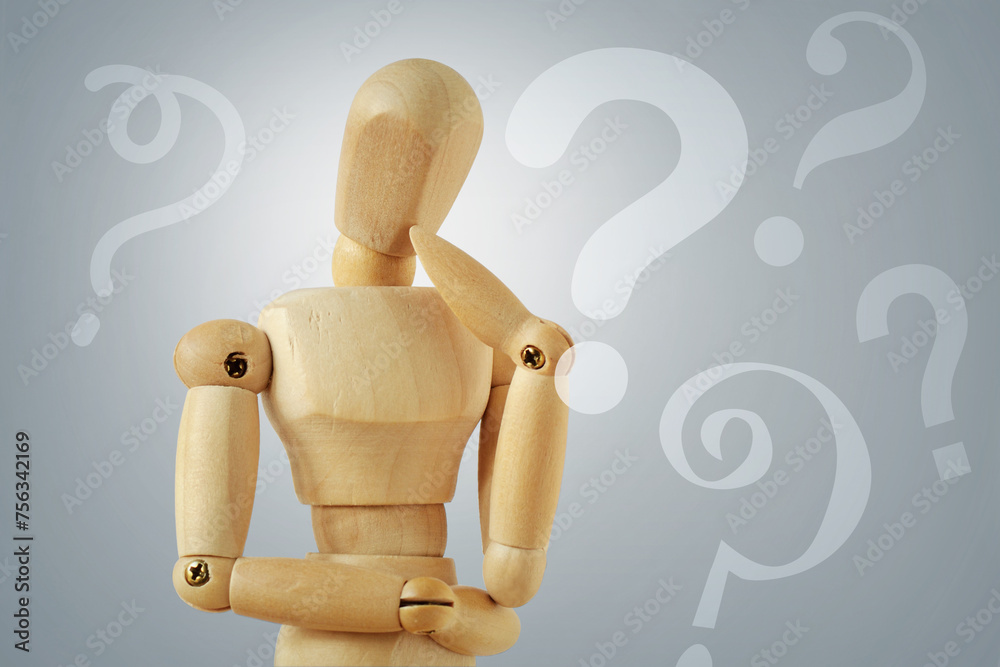 Wooden mannequin in thinking pose with quesion marks - Concept of question thinking and doubts Wooden mannequin in thinking pose with quesion marks - Concept of question thinking and doubts