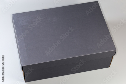 Closed gray cardboard shoebox on gray background, top view