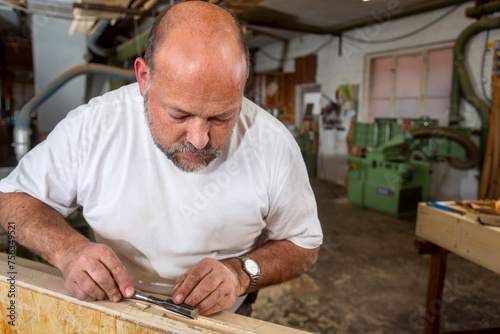 Tischler arbeitet in seiner Werkstatt mit Stechbeitel
